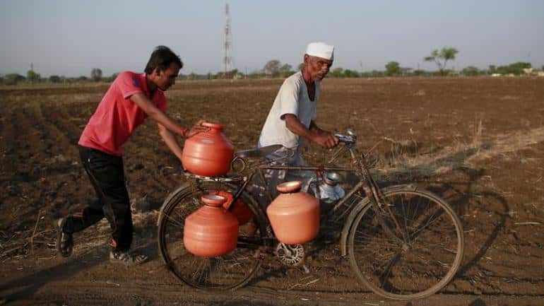 Man carries pots to fill them with water in drought stricken Maharashtra